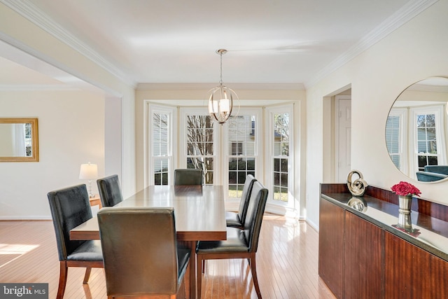 dining area with baseboards, light wood finished floors, and crown molding