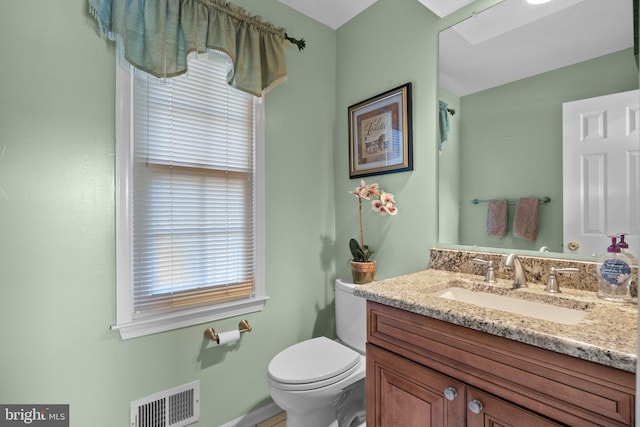 bathroom featuring visible vents, toilet, and vanity