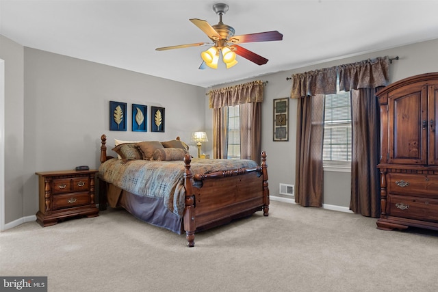 bedroom featuring a ceiling fan, light colored carpet, visible vents, and baseboards