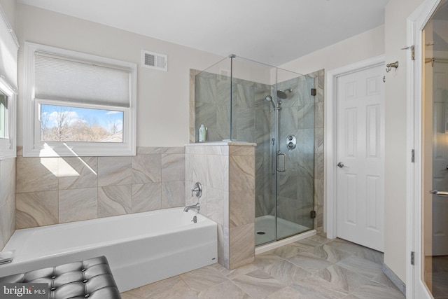 full bathroom with a garden tub, visible vents, and a shower stall