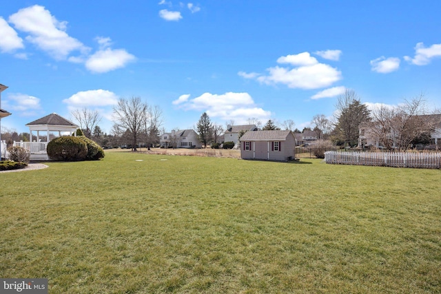 view of yard featuring an outbuilding, a shed, and fence