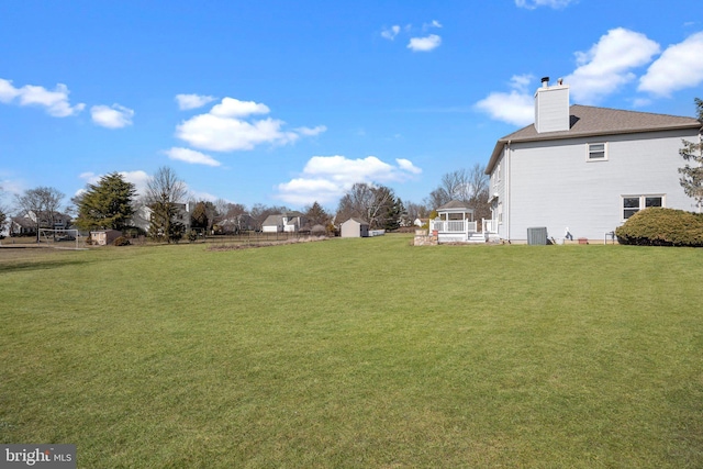 view of yard featuring a storage unit, an outbuilding, and central AC