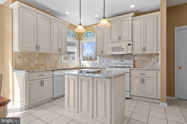 kitchen with a sink, decorative light fixtures, white appliances, and light tile patterned floors