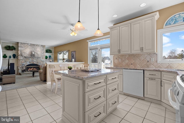 kitchen featuring open floor plan, white range with electric stovetop, light tile patterned flooring, a fireplace, and dishwashing machine