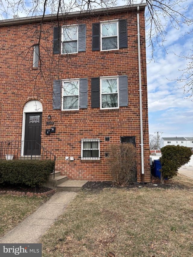 view of front of house with a front yard and brick siding