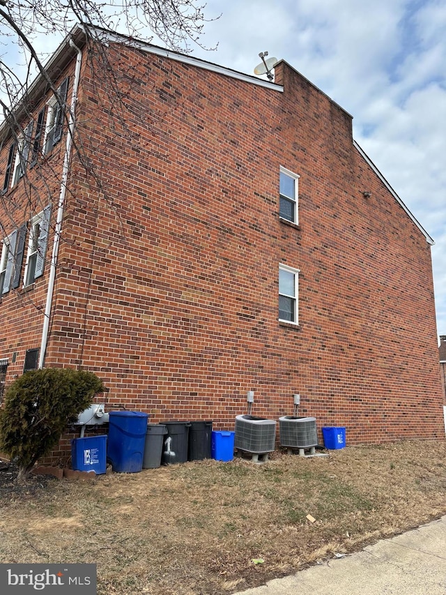 view of property exterior featuring brick siding and central AC unit