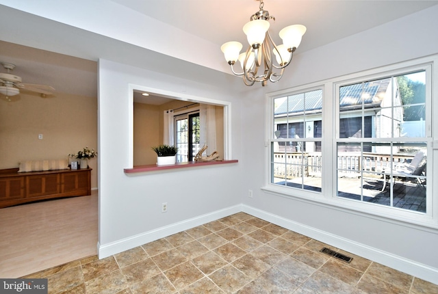 unfurnished dining area with ceiling fan with notable chandelier, visible vents, and baseboards