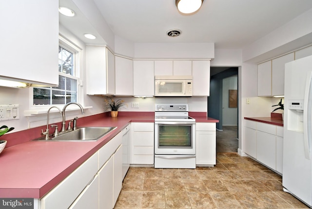 kitchen featuring white appliances, a sink, visible vents, and white cabinets