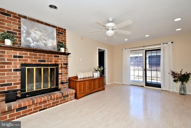 living area with baseboards, ceiling fan, wood finished floors, a fireplace, and recessed lighting