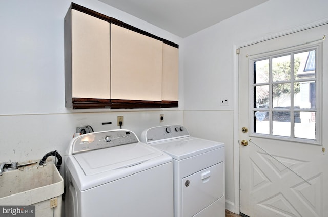 laundry area featuring a sink, washing machine and clothes dryer, and cabinet space