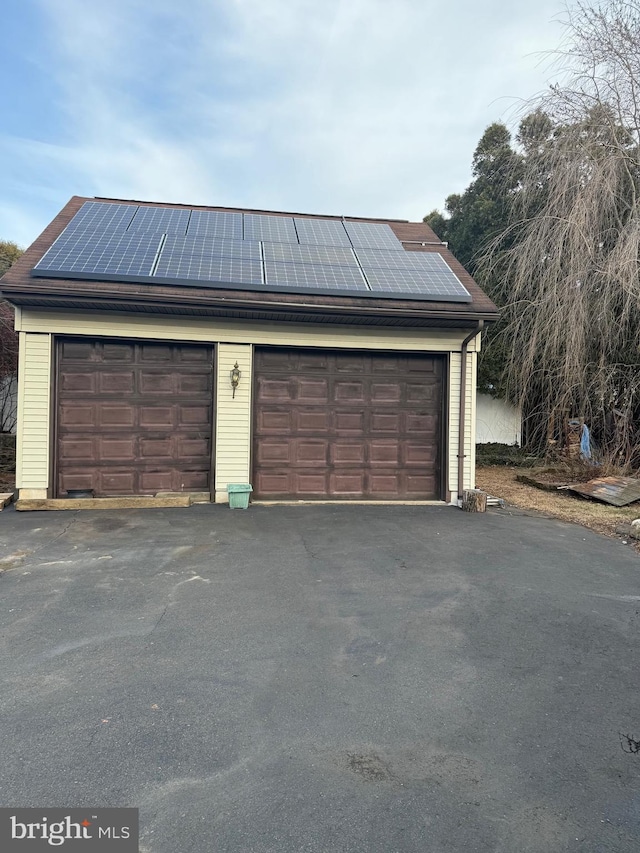 detached garage featuring solar panels