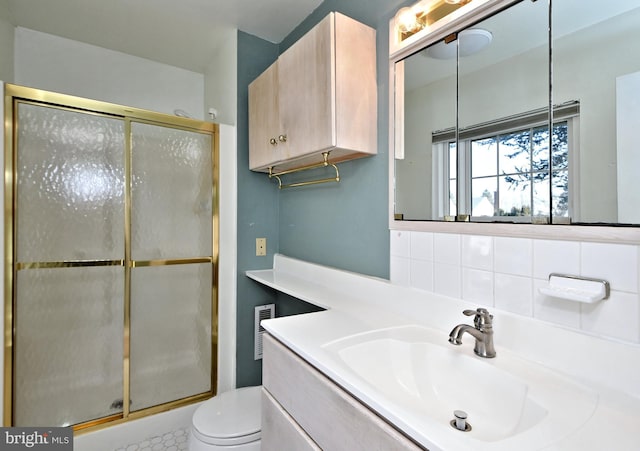 full bathroom featuring a stall shower, visible vents, toilet, vanity, and backsplash