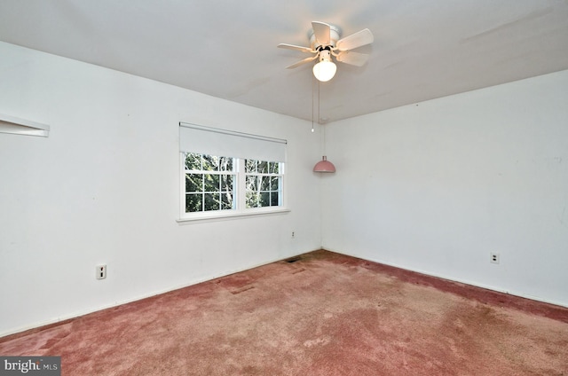 carpeted spare room with a ceiling fan