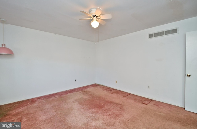 carpeted spare room with ceiling fan and visible vents