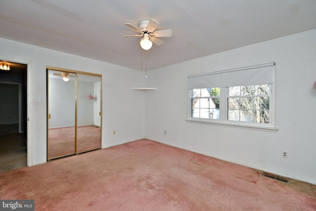 unfurnished bedroom featuring carpet, visible vents, and ceiling fan