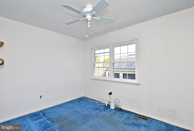 empty room featuring carpet floors, ceiling fan, and visible vents