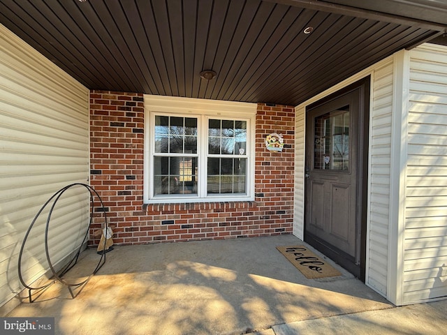 doorway to property with brick siding