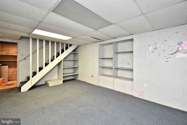 finished below grade area with carpet floors, stairs, and a paneled ceiling