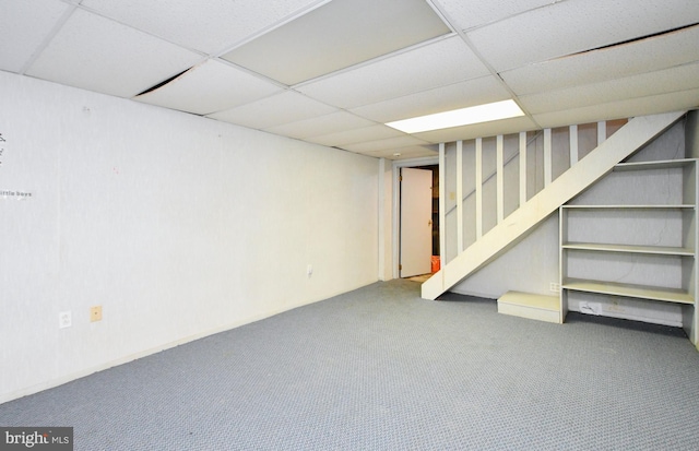 finished below grade area featuring a drop ceiling, carpet flooring, and stairs