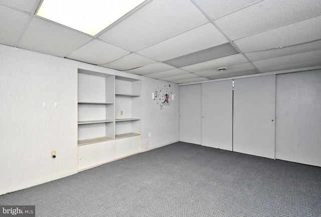 finished below grade area featuring a drop ceiling and carpet