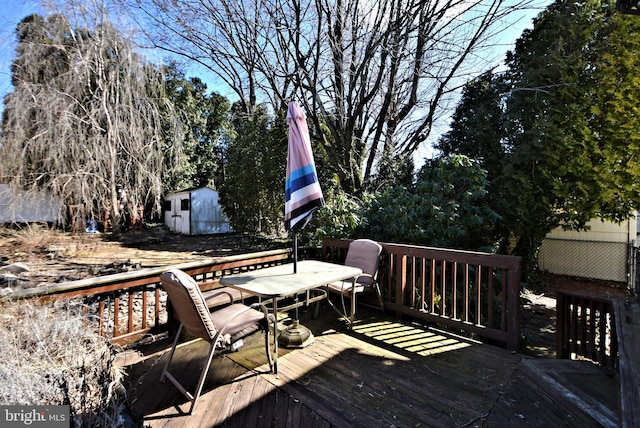 deck featuring a storage shed, an outbuilding, and outdoor dining space