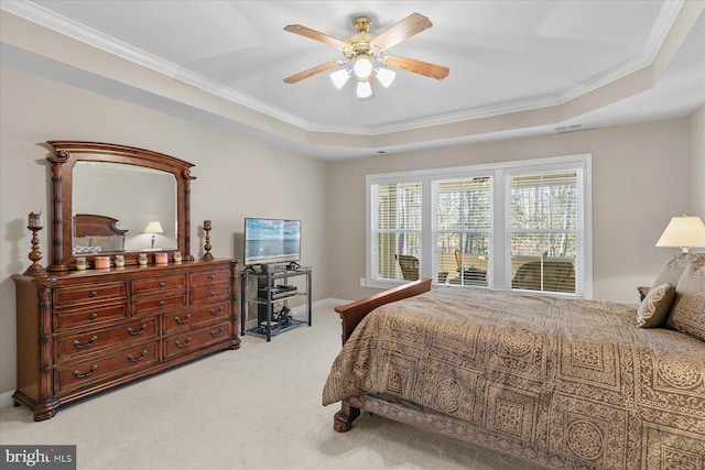 bedroom with visible vents, ornamental molding, a ceiling fan, a tray ceiling, and light colored carpet