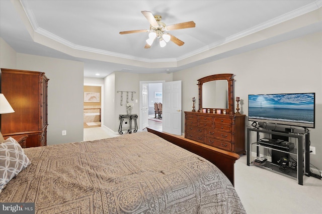 carpeted bedroom featuring ensuite bathroom, a ceiling fan, crown molding, and a tray ceiling