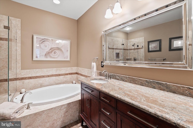 bathroom featuring a garden tub, vanity, and a tile shower