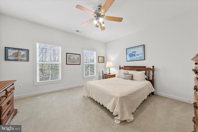 bedroom with baseboards, light carpet, visible vents, and a ceiling fan