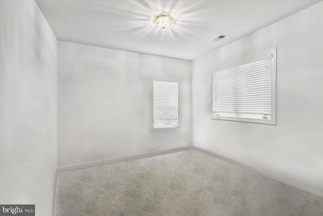 unfurnished room with carpet flooring, baseboards, and visible vents