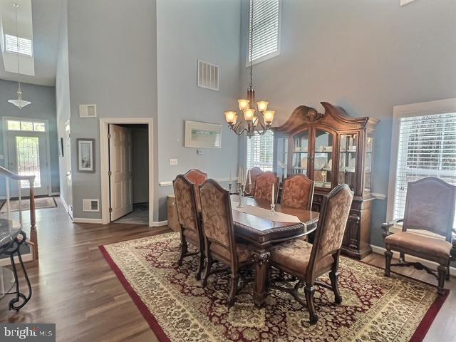 dining area featuring a wealth of natural light, visible vents, and dark wood-style floors