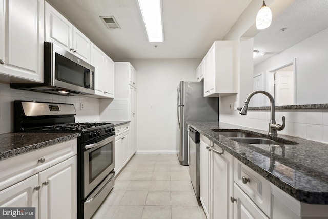 kitchen with light tile patterned floors, white cabinetry, appliances with stainless steel finishes, and a sink