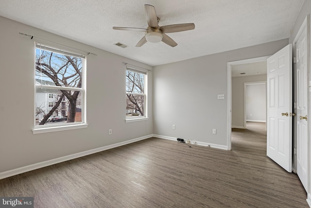 unfurnished bedroom with visible vents, a textured ceiling, baseboards, and wood finished floors