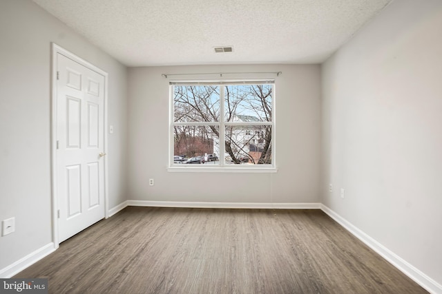 unfurnished bedroom with visible vents, baseboards, and wood finished floors