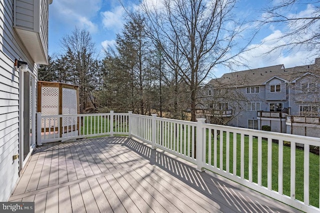 wooden deck featuring a yard and a residential view