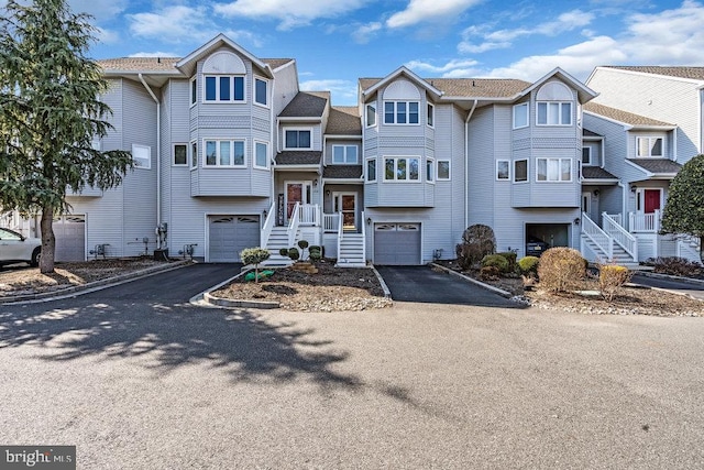 view of front of home featuring aphalt driveway, a residential view, and a garage