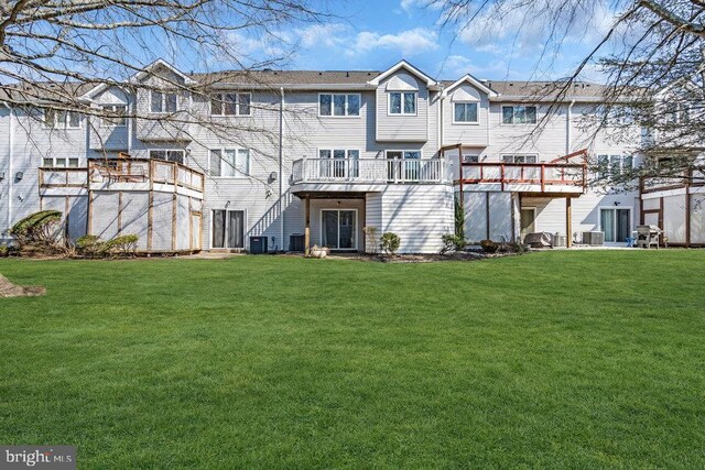 back of property featuring a yard and central AC