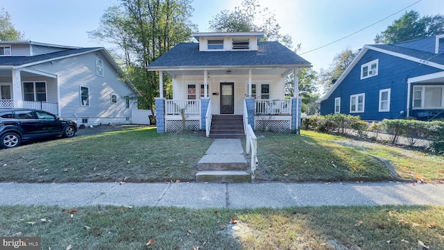 bungalow-style house featuring a porch, a shingled roof, a front lawn, and fence