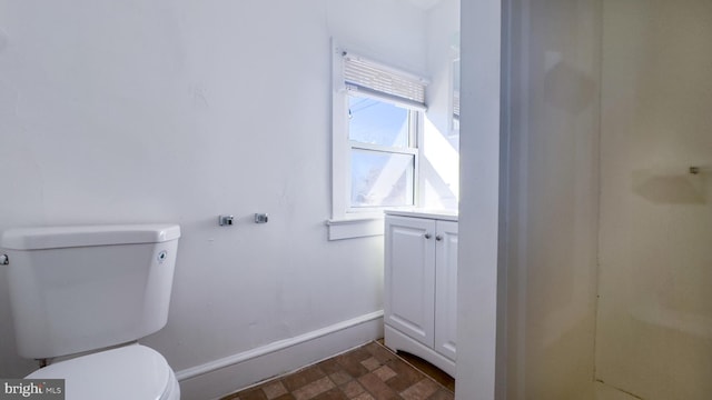 bathroom featuring toilet and baseboards