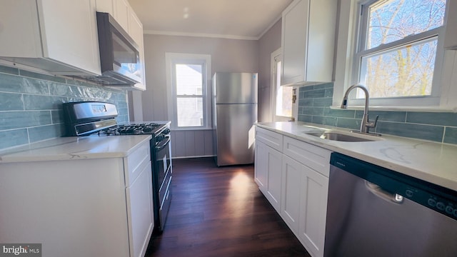 kitchen with stainless steel appliances, dark wood-style flooring, a sink, and white cabinets