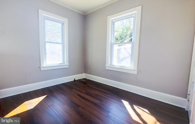 spare room with baseboards and dark wood-style flooring