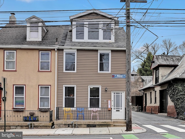 townhome / multi-family property featuring covered porch and roof with shingles