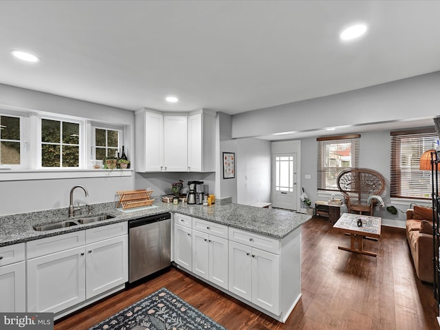 kitchen featuring dark wood finished floors, a peninsula, a sink, white cabinets, and stainless steel dishwasher