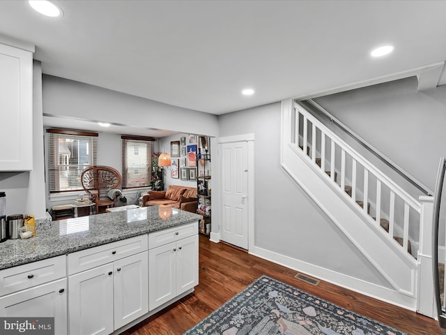 kitchen featuring dark wood finished floors, visible vents, white cabinets, and a peninsula