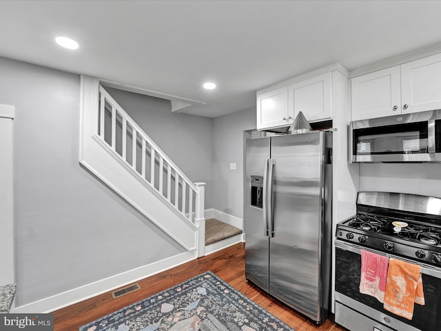 kitchen with visible vents, baseboards, appliances with stainless steel finishes, wood finished floors, and white cabinetry