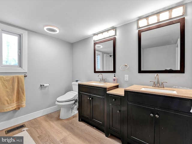 full bath featuring visible vents, toilet, wood finished floors, baseboards, and vanity