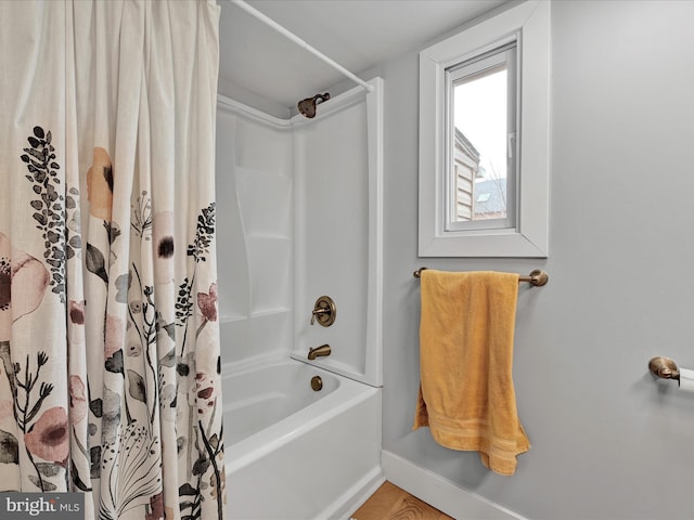 bathroom with baseboards and shower / tub combo with curtain