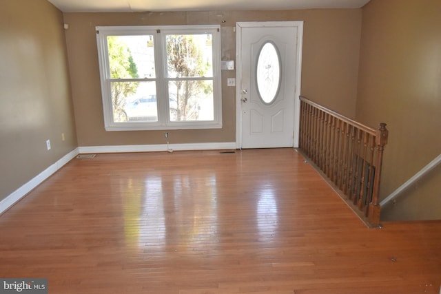 entryway with hardwood / wood-style floors, visible vents, and baseboards