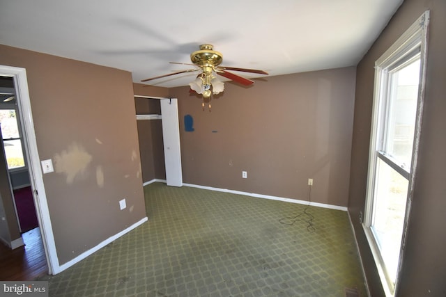 empty room featuring carpet floors, ceiling fan, and baseboards