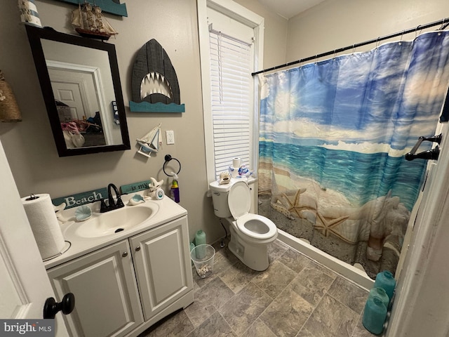 full bath with a shower with shower curtain, stone finish floor, toilet, and vanity